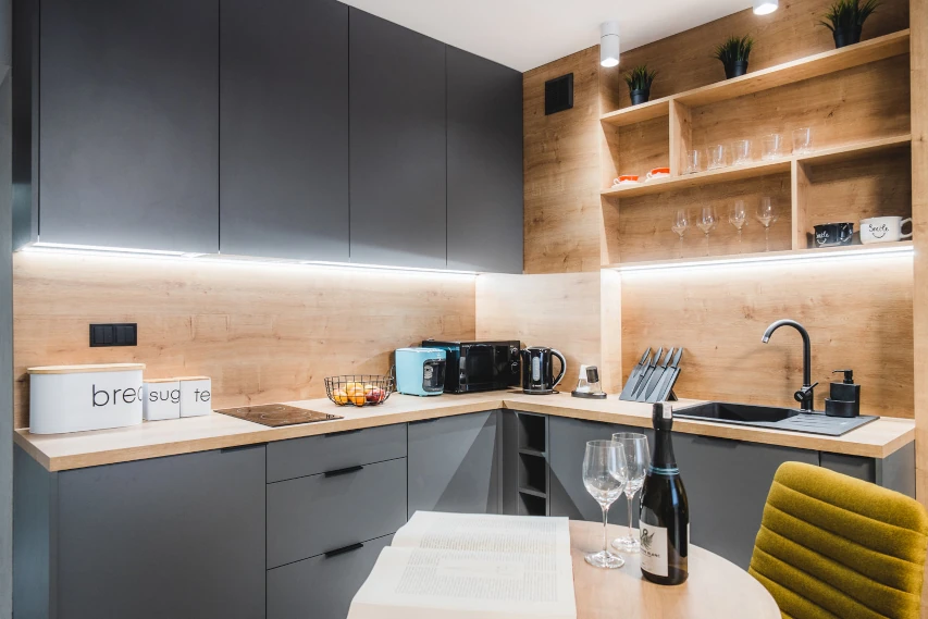 Kuchnia w zabudowie z drewnianymi frontami w apartamencie w Toruniu