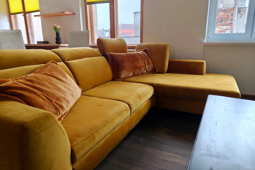 Gigantyczna żółta kanapa w apartamencie w Toruniu